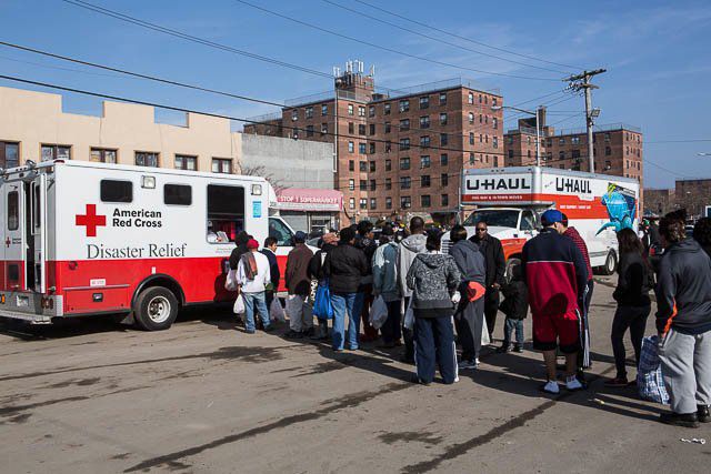 Residents in Rockaway Beach line up for lunch at a Red Cross truck